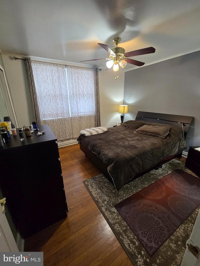 bedroom with ceiling fan and dark hardwood / wood-style flooring