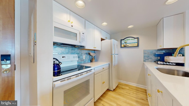 kitchen featuring white cabinetry, tasteful backsplash, white appliances, light hardwood / wood-style flooring, and sink