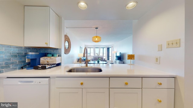 kitchen with pendant lighting, dishwasher, white cabinetry, decorative backsplash, and sink