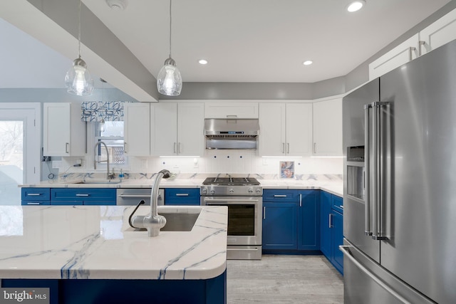 kitchen featuring decorative backsplash, blue cabinets, stainless steel appliances, under cabinet range hood, and a sink