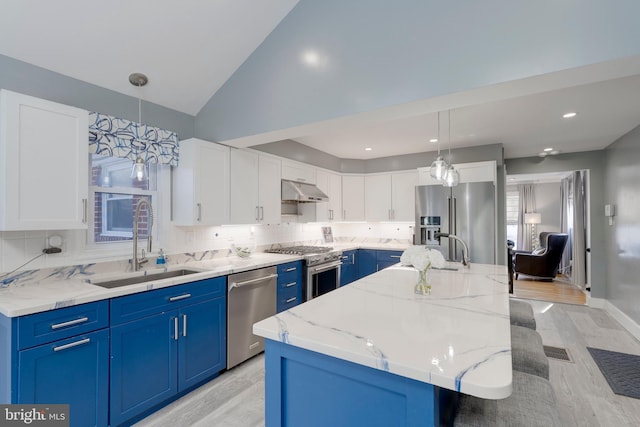 kitchen featuring high end appliances, blue cabinets, a sink, and under cabinet range hood