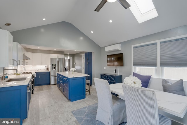 kitchen with stainless steel fridge with ice dispenser, a kitchen breakfast bar, blue cabinets, under cabinet range hood, and a sink