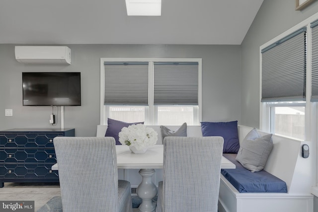 dining space with vaulted ceiling and a wall unit AC