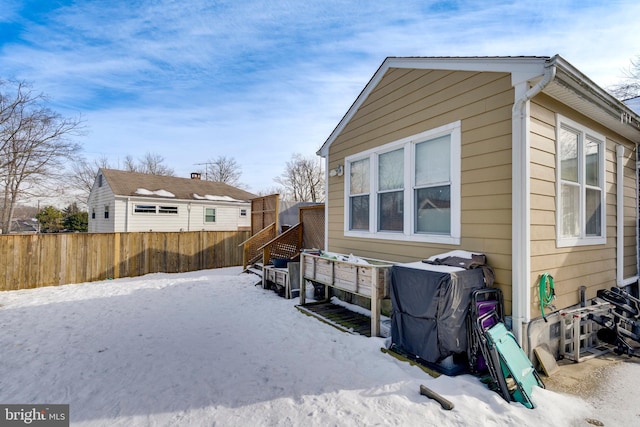 snow covered property with fence