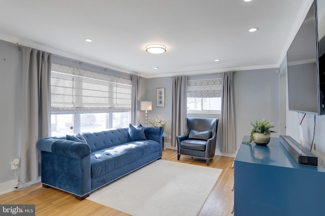 living room featuring light wood finished floors, baseboards, crown molding, and recessed lighting