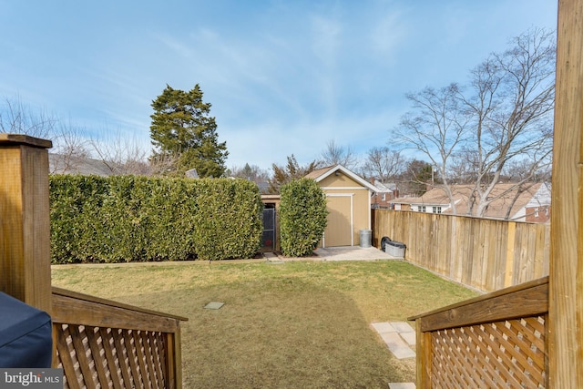 view of yard featuring an outbuilding, a storage unit, and a fenced backyard