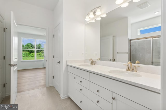 bathroom featuring tile patterned flooring, plenty of natural light, vanity, and an enclosed shower