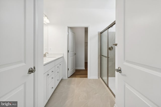 bathroom featuring walk in shower and vanity