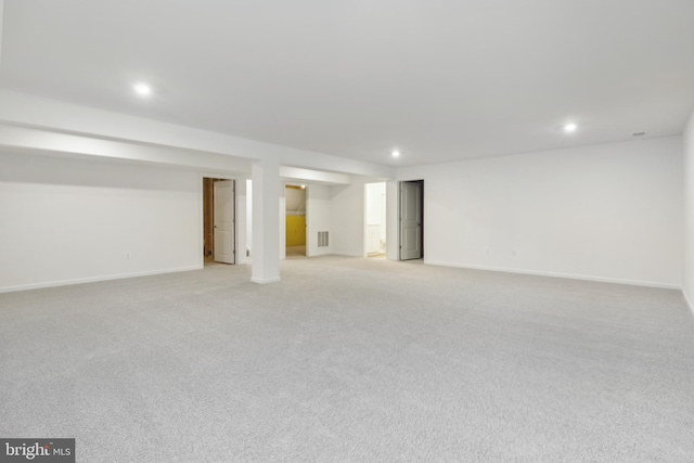 basement featuring light carpet