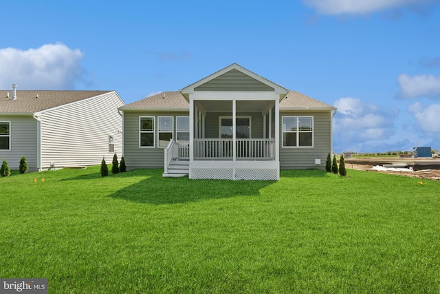 rear view of house with a yard and a sunroom