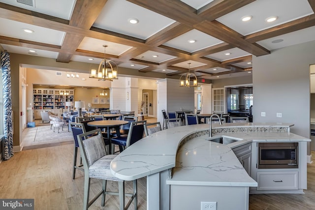 kitchen featuring sink, pendant lighting, and a large island with sink