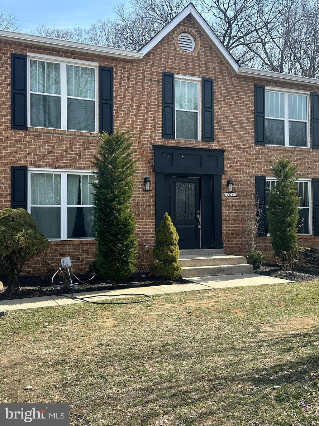 view of front facade featuring brick siding and a front lawn