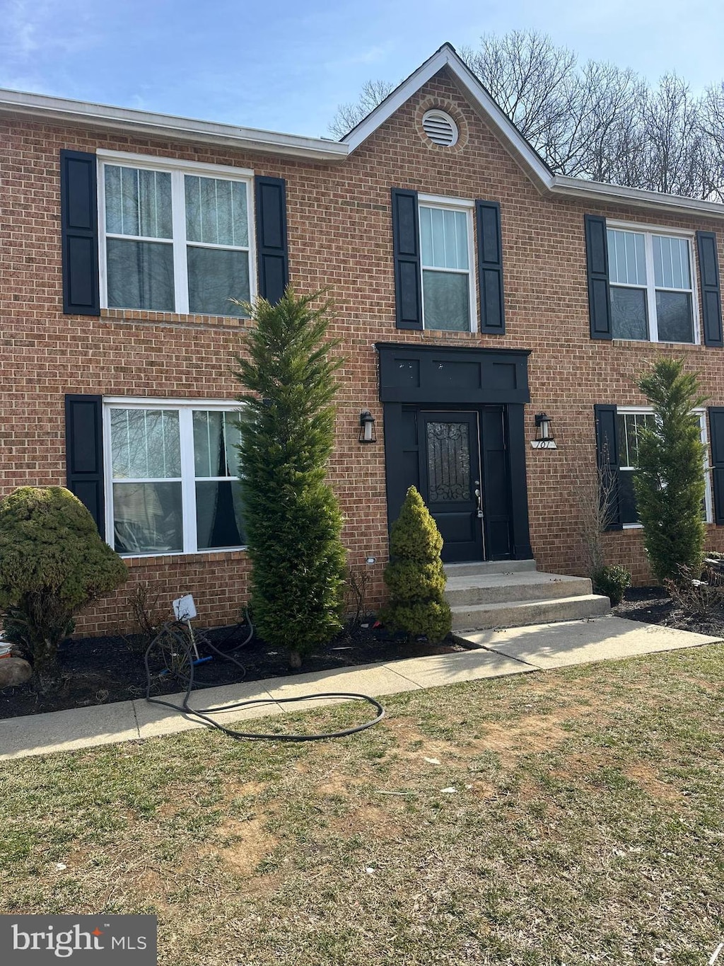 view of front of home with a front yard and brick siding