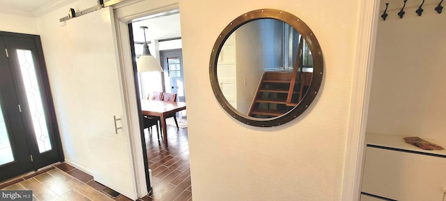 entrance foyer featuring ornamental molding and a barn door