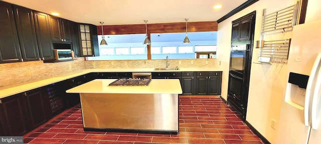 kitchen featuring decorative light fixtures, sink, decorative backsplash, and a center island