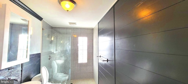 bathroom featuring tile walls, toilet, and a tile shower