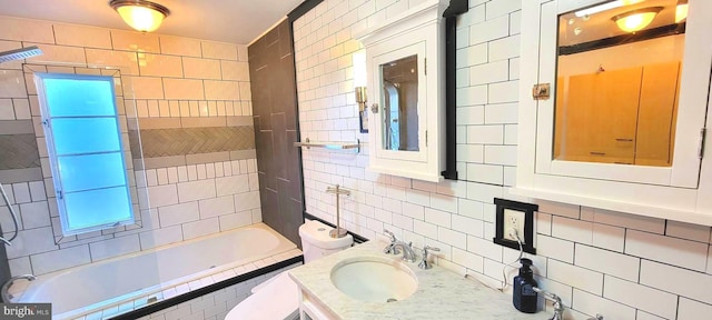 bathroom featuring tile walls, toilet, vanity, and tasteful backsplash