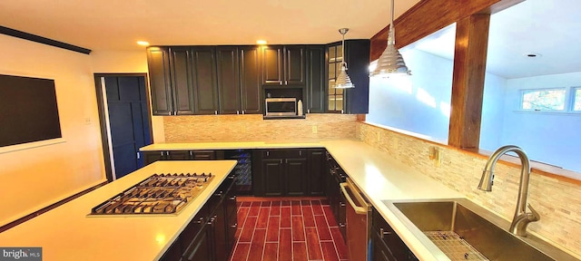 kitchen featuring tasteful backsplash, sink, stainless steel appliances, and pendant lighting