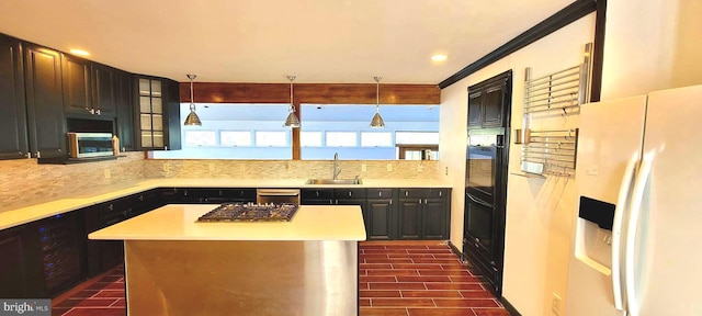 kitchen with sink, pendant lighting, appliances with stainless steel finishes, and a center island