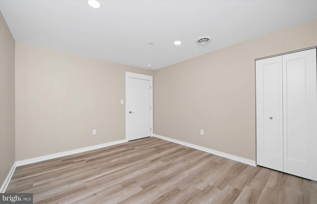 unfurnished bedroom featuring light wood-type flooring and a closet