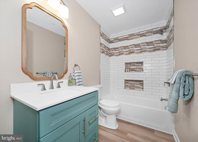 full bathroom featuring hardwood / wood-style floors, toilet, vanity, and tiled shower / bath combo