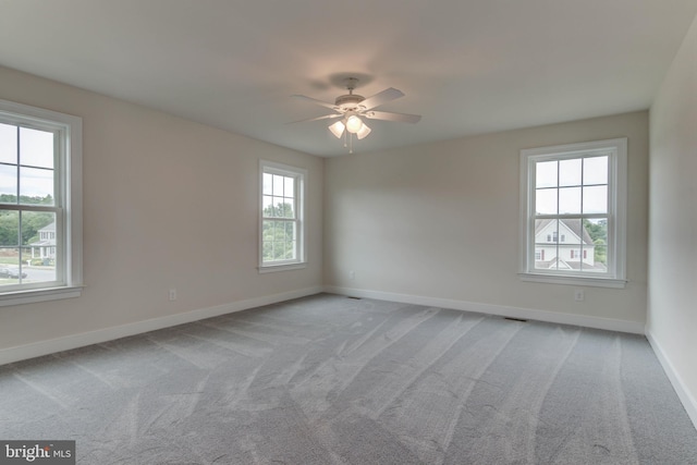 spare room featuring ceiling fan and light colored carpet