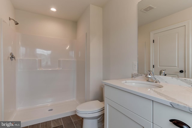 bathroom with a shower, toilet, and vanity