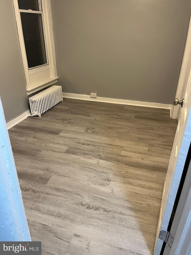 spare room with hardwood / wood-style flooring and radiator heating unit