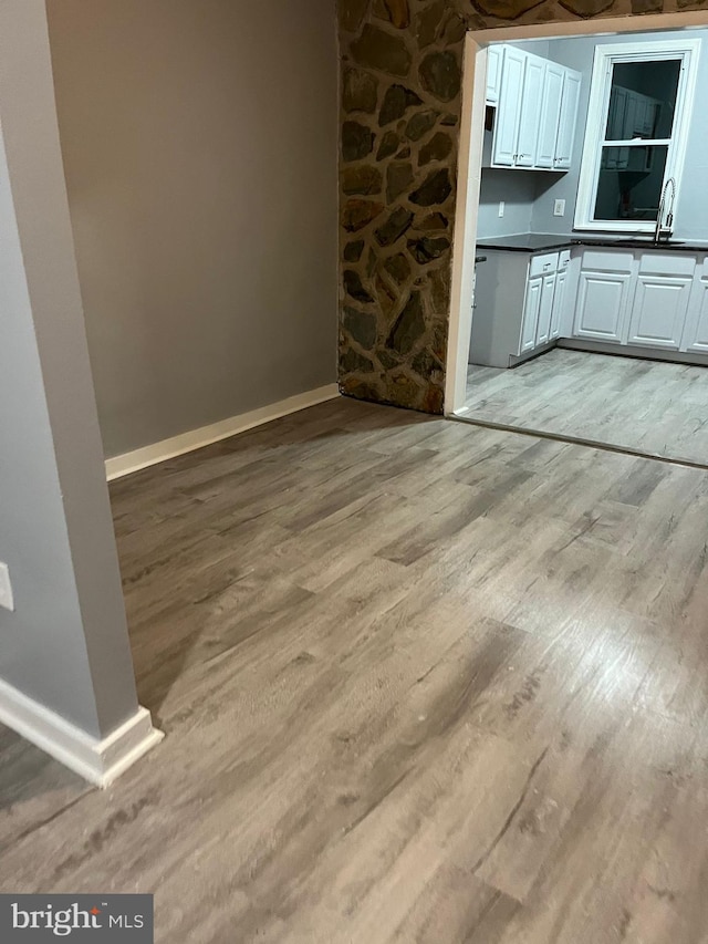 unfurnished dining area featuring light wood-type flooring and sink