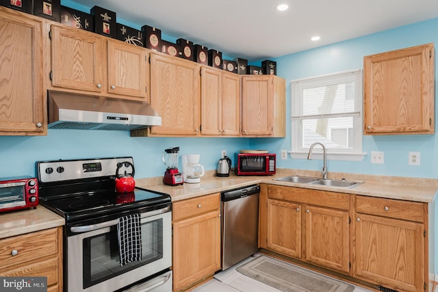 kitchen with appliances with stainless steel finishes, light brown cabinetry, and sink