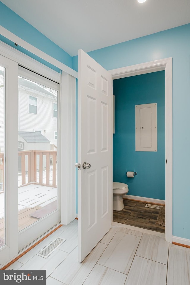 bathroom featuring toilet and electric panel