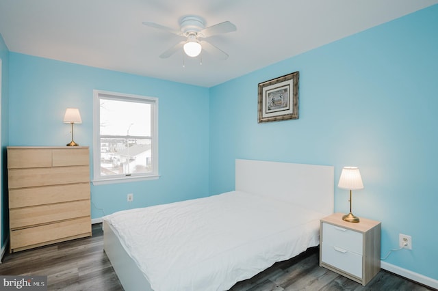 bedroom with dark hardwood / wood-style flooring and ceiling fan