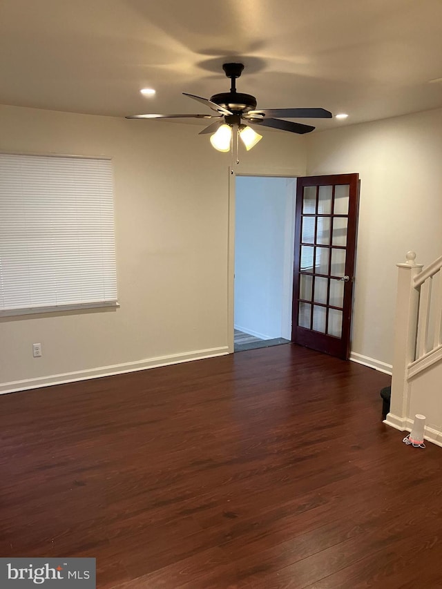 spare room with ceiling fan, dark hardwood / wood-style floors, and french doors