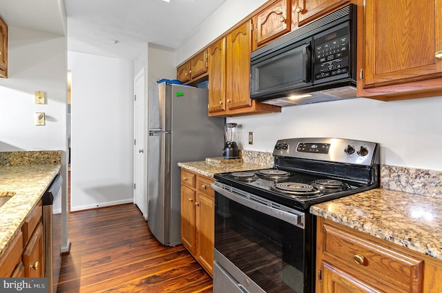 kitchen with stainless steel appliances, brown cabinets, dark wood-type flooring, and light stone countertops