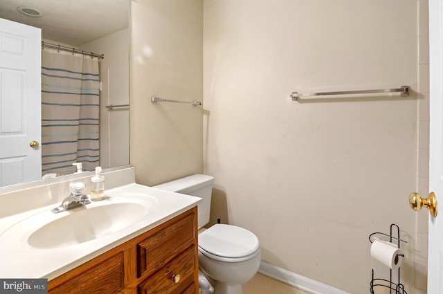 bathroom with curtained shower, vanity, and toilet