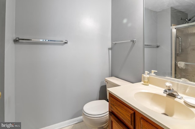 full bath with toilet, vanity, baseboards, and a shower with shower door