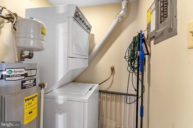 clothes washing area with laundry area, water heater, electric panel, and stacked washer and clothes dryer