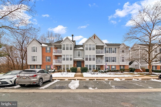 view of front of property with uncovered parking and brick siding