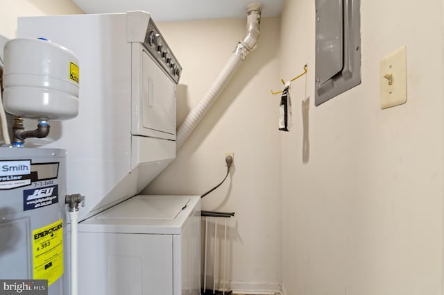 laundry area featuring stacked washer / drying machine, laundry area, electric panel, and water heater