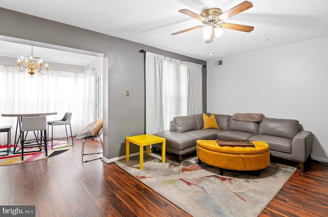 living area with visible vents, baseboards, wood finished floors, and ceiling fan with notable chandelier