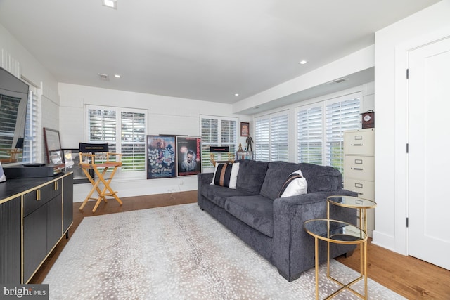 living area with visible vents, recessed lighting, and wood finished floors