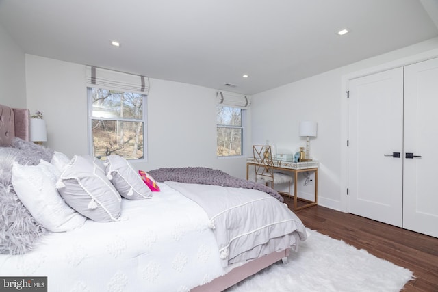 bedroom featuring recessed lighting, a closet, multiple windows, and wood finished floors