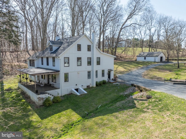 view of home's exterior featuring a shingled roof, a yard, driveway, and a chimney