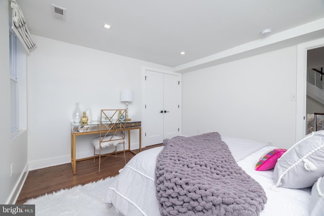 bedroom featuring wood finished floors, visible vents, baseboards, recessed lighting, and a closet