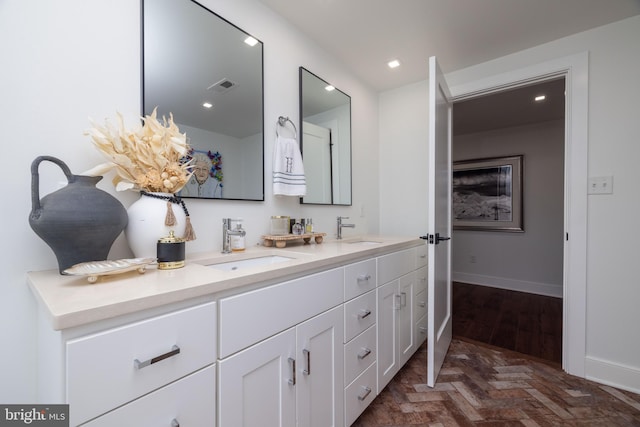 bathroom with double vanity, recessed lighting, visible vents, and a sink