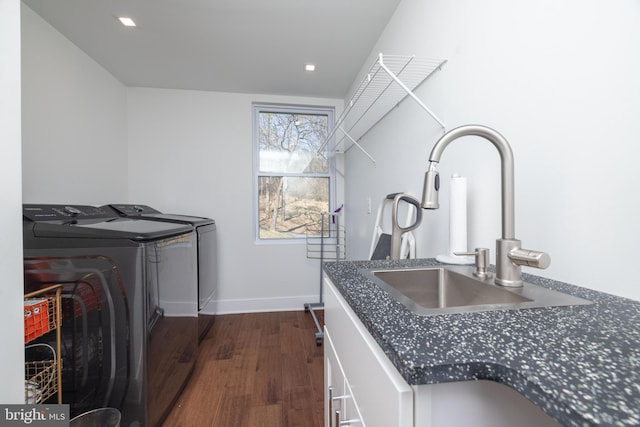 laundry room featuring baseboards, dark wood finished floors, laundry area, a sink, and independent washer and dryer