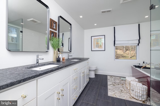 full bathroom with double vanity, visible vents, and a sink