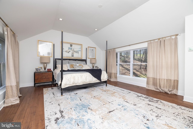 bedroom with baseboards, lofted ceiling, and wood finished floors