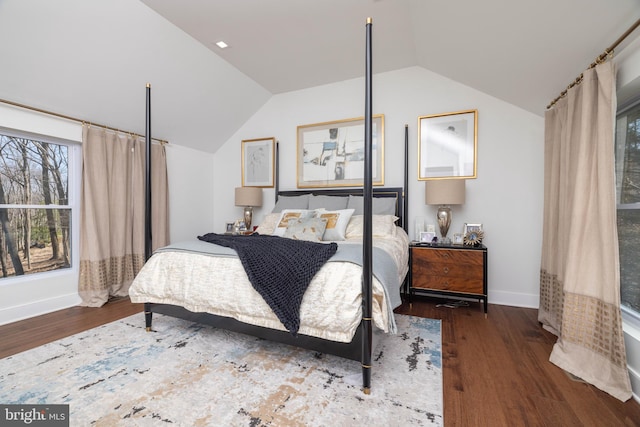 bedroom with baseboards, wood finished floors, and vaulted ceiling