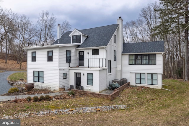 modern farmhouse with a chimney, central AC, and a shingled roof